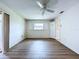 Empty bedroom with hardwood floors, ceiling fan, and a bright window with shutters at 11920 Boynton Ln # 11920, New Port Richey, FL 34654