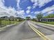 Entrance to a gated community featuring an American flag, landscaping, and blue skies at 11920 Boynton Ln # 11920, New Port Richey, FL 34654