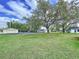 Expansive green lawn and trees amidst a quiet residential community and covered parking areas at 11920 Boynton Ln # 11920, New Port Richey, FL 34654