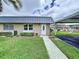 Inviting home featuring a well-manicured lawn, charming brick accents, and convenient carport at 11920 Boynton Ln # 11920, New Port Richey, FL 34654