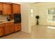 Kitchen with wood cabinets, black appliances, and tile floor at 5163 Tangelo Dr, New Port Richey, FL 34652