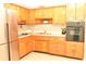 Bright kitchen featuring wood cabinets, stainless steel appliances, and mosaic tile backsplash at 5163 Tangelo Dr, New Port Richey, FL 34652