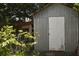 Metal storage shed with white door in backyard at 5163 Tangelo Dr, New Port Richey, FL 34652