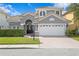 Two story house with gray siding, white garage door, and landscaping at 10616 Cape Hatteras Dr, Tampa, FL 33615