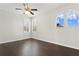 Bright bedroom with dark hardwood floors, ceiling fan, and large windows at 10616 Cape Hatteras Dr, Tampa, FL 33615