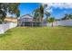Large grassy backyard with home and white fence at 10616 Cape Hatteras Dr, Tampa, FL 33615