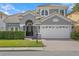 Two-story home with gray exterior, three-car garage, and manicured lawn at 10616 Cape Hatteras Dr, Tampa, FL 33615