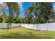 Private backyard with lush landscaping and white fence at 10616 Cape Hatteras Dr, Tampa, FL 33615