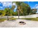 Landscaped backyard with fire pit and palm trees at 10616 Cape Hatteras Dr, Tampa, FL 33615