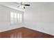 Simple bedroom with hardwood floors, white wainscoting, and ceiling fan at 10616 Cape Hatteras Dr, Tampa, FL 33615