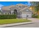 Two-story home with gray exterior, three-car garage, and manicured lawn at 10616 Cape Hatteras Dr, Tampa, FL 33615
