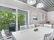 White dining table with chairs, providing access to a private balcony at 156 175Th E Ave, Redington Shores, FL 33708