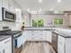 Modern kitchen with white cabinets, stainless steel appliances, and a large island at 156 175Th E Ave, Redington Shores, FL 33708