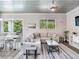 Bright living room with sectional sofa, large TV, and dining area at 156 175Th E Ave, Redington Shores, FL 33708