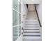 Modern staircase with white risers and dark wood handrail, leading to the upper level at 160 174Th Terrace E Dr # A, Redington Shores, FL 33708