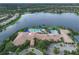 Aerial view displays a community clubhouse next to a large pond, surrounded by landscaping at 15911 Cobble Mill Dr, Wimauma, FL 33598