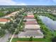 Aerial view of a neighborhood next to a pond with well-maintained lawns at 15911 Cobble Mill Dr, Wimauma, FL 33598