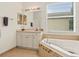 Bright bathroom featuring a soaking tub, vanity, and a large window at 15911 Cobble Mill Dr, Wimauma, FL 33598