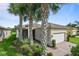 Charming single-story home featuring a brick driveway, two-car garage, and palm trees at 15911 Cobble Mill Dr, Wimauma, FL 33598