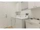 Functional laundry room with modern appliances, sink and ample storage at 15911 Cobble Mill Dr, Wimauma, FL 33598