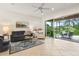 Bright living room with tile flooring, ceiling fan, and seamless access to the screened patio at 15911 Cobble Mill Dr, Wimauma, FL 33598