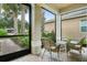 Comfortable outdoor seating on a covered brick patio with palm tree view at 15911 Cobble Mill Dr, Wimauma, FL 33598