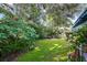 Green backyard with mature trees and plants at 509 Langford Cir, Plant City, FL 33563