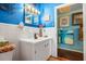 White bathroom vanity with blue walls and a view of hallway at 509 Langford Cir, Plant City, FL 33563