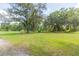 Open grassy area with mature trees and landscaping at 2804 Holloway Rd, Plant City, FL 33567