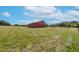Red barn with covered stalls and fenced pasture at 8703 Alafia Hills Dr, Plant City, FL 33567
