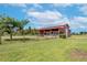 Rustic red barn with covered stalls, ideal for horses at 8703 Alafia Hills Dr, Plant City, FL 33567