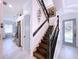 Modern staircase with dark wood treads and metal railing, and a view of the kitchen at 6564 Simone Shores Cir, Apollo Beach, FL 33572