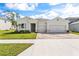 Beautiful one story home boasting a spacious three-car garage, lush green lawn and clear blue skies at 23176 Pachino Way, Lutz, FL 33549