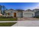 Charming single-story home featuring a spacious three-car garage and beautifully landscaped front yard at 23176 Pachino Way, Lutz, FL 33549