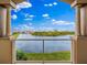 Framed balcony view showcasing serene lake vistas and verdant landscaping under a bright blue sky at 43 Bayview S Ct # A, St Petersburg, FL 33711