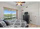 Bedroom with ceiling fan, balcony overlooking a lake view, and adjacent dresser with mounted TV at 43 Bayview S Ct # A, St Petersburg, FL 33711