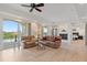 Comfortable living room with hardwood floors, ceiling fan, and sliding glass doors offering picturesque lake views at 43 Bayview S Ct # A, St Petersburg, FL 33711