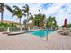 Inviting community pool and spa with lounge chairs and mature palm trees with clear, blue skies at 43 Bayview S Ct # A, St Petersburg, FL 33711