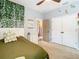 Light and airy bedroom with a green duvet, white dresser, and double doors at 32216 Cottage Glen Ln, Wesley Chapel, FL 33545