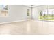 Bright living room with tile floors and sliding glass doors leading to a lake view at 23176 Pachino Way, Lutz, FL 33549