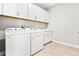 Laundry room with washer, dryer and white cabinets at 23176 Pachino Way, Lutz, FL 33549