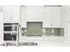 Modern kitchen with white cabinets, quartz countertops, and stainless steel appliances at 23176 Pachino Way, Lutz, FL 33549