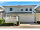 Two-story home with a light teal exterior, white trim, and a gray metal roof at 108 Aberdeen Pond Dr, Apollo Beach, FL 33572