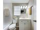 Comfortable bathroom with an updated vanity, white toilet, and updated light fixtures and mirror at 1709 E Sitka St, Tampa, FL 33604