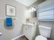 Comfortable bathroom with tile flooring, updated vanity, white toilet, and framed decorative print at 1709 E Sitka St, Tampa, FL 33604