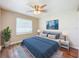 Cozy bedroom featuring a ceiling fan, plush bedding, laminate wood flooring, and neutral colored walls at 1709 E Sitka St, Tampa, FL 33604