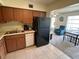 Functional kitchen layout with appliances and tile floors leading to a seating area with a bright window at 2385 Tahitian Ln # 63, Clearwater, FL 33763