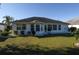 Home's backyard features a grassy lawn, small trees, and a patio at 2451 E Del Webb Blvd, Sun City Center, FL 33573