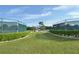 Two tennis courts with lush landscaping and a shaded seating area at 2451 E Del Webb Blvd, Sun City Center, FL 33573