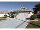 White house with attached two-car garage, landscaping, and a paved driveway at 2451 E Del Webb Blvd, Sun City Center, FL 33573